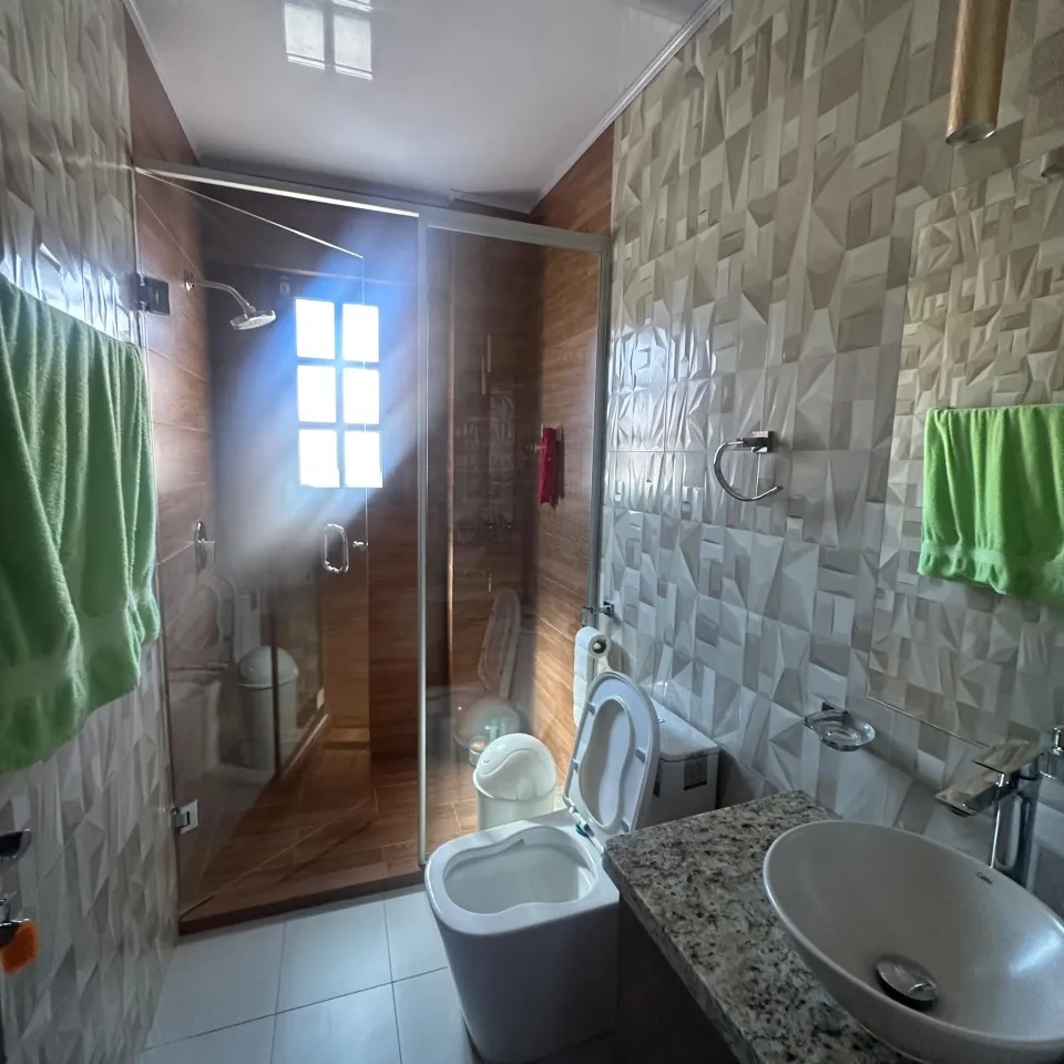 Baño con ducha y revestimiento de piedra
